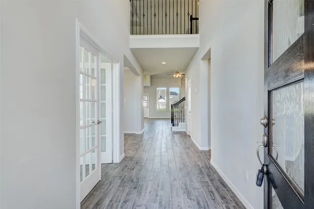 a view of a hallway with wooden floor and staircase