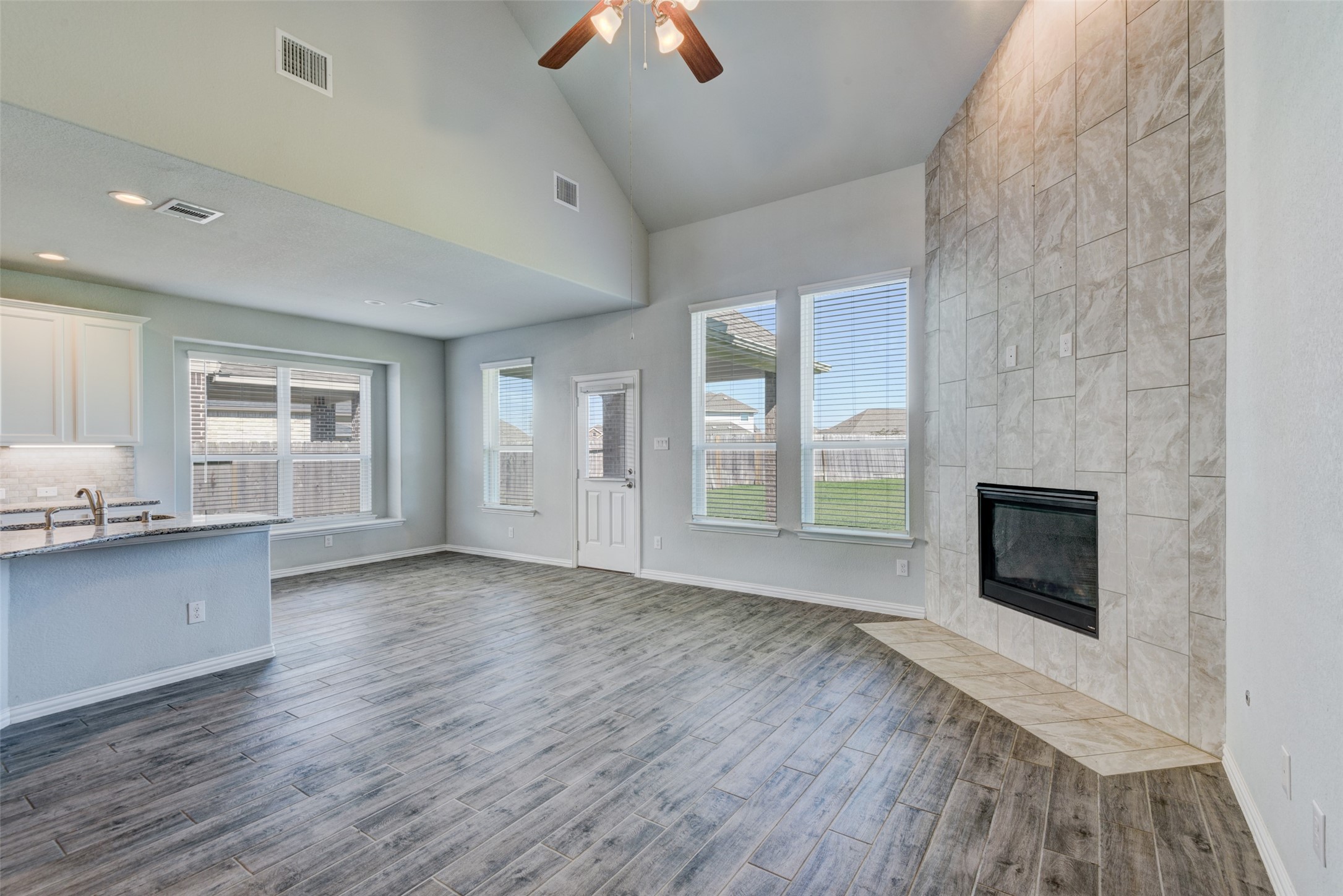 23421 Vineyard Drive Alvin, TX 77511 - Photo 7 of 32 an empty room with windows fireplace and wooden floor