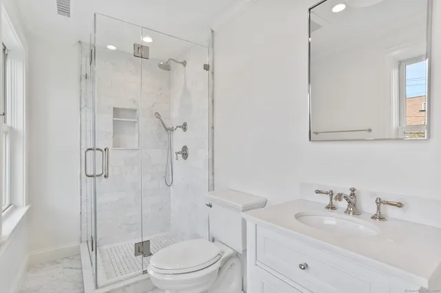 a bathroom with a sink toilet vanity and shower