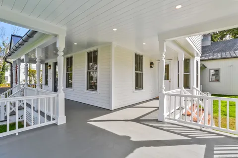 a view of a hallway with wooden floor and windows