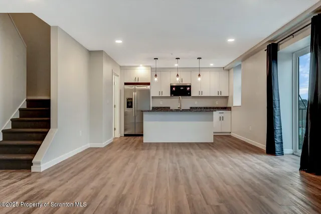 a view of kitchen with wooden floor and electronic appliances
