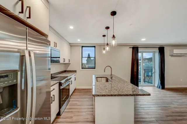 a kitchen with stainless steel appliances granite countertop a sink and refrigerator