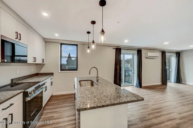 a kitchen with stainless steel appliances granite countertop a sink refrigerator and cabinets