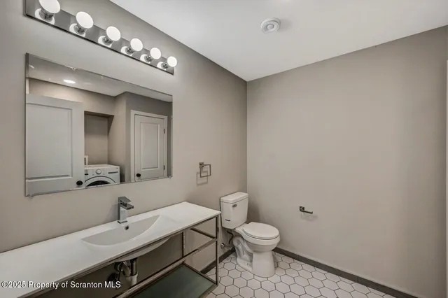 a bathroom with a toilet sink and mirror