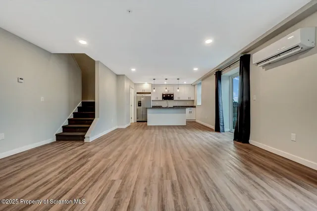 a view of kitchen with refrigerator stove and wooden floor