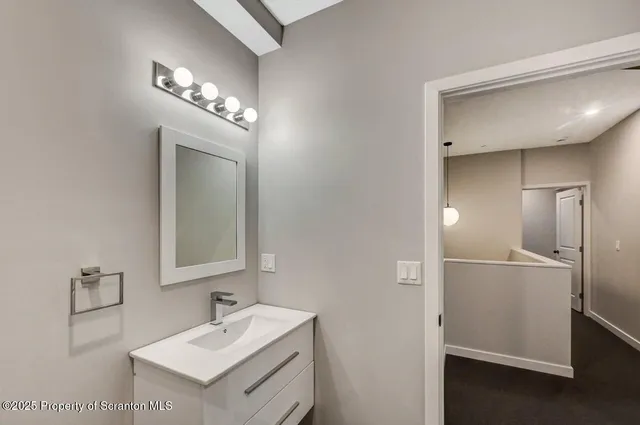 a bathroom with a toilet sink vanity and mirror