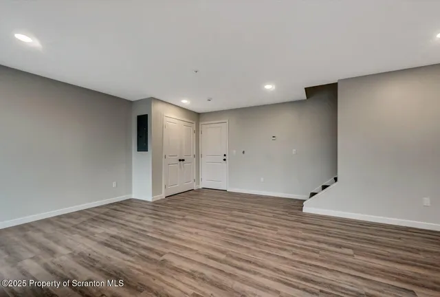 a view of an empty room with wooden floor