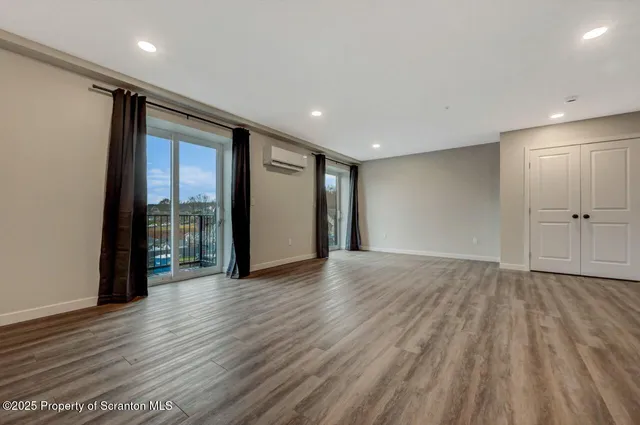 a view of an empty room with wooden floor