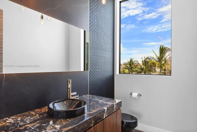 a bedroom with a bed and dresser with wooden floor