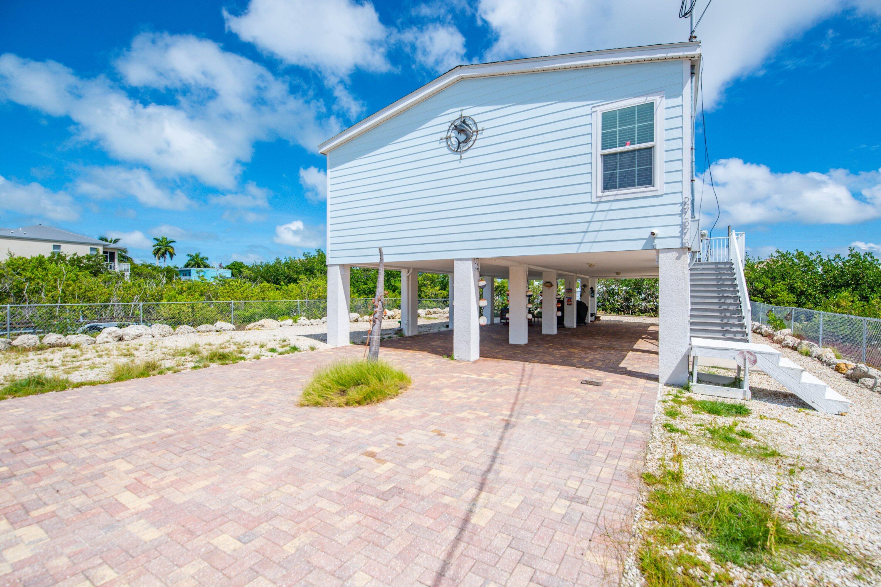27373 Antigua Road Summerland Key, FL 33042 - Photo 21 of 31 a view of a patio with a table and chairs under an umbrella