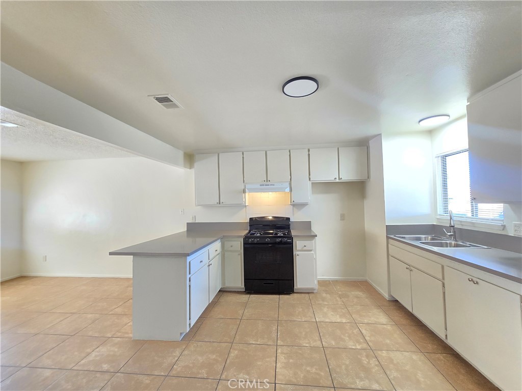 8318 Dogbane Avenue, Unit A California City, CA 93505 - Photo 2 of 12 a kitchen with stainless steel appliances kitchen island granite countertop a sink and cabinets