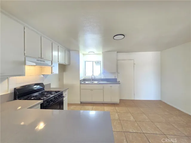 a kitchen with a sink and a stove top oven