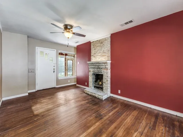 a view of a livingroom with a fireplace and wooden floor