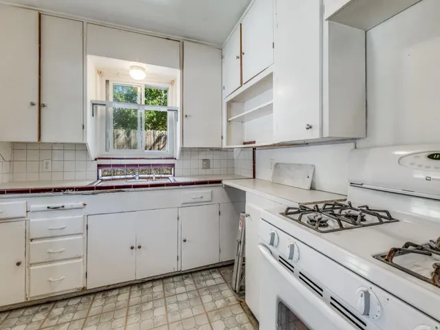 a kitchen with granite countertop white cabinets and white appliances