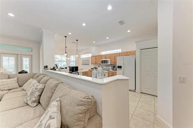 a large white kitchen with a large window and stainless steel appliances