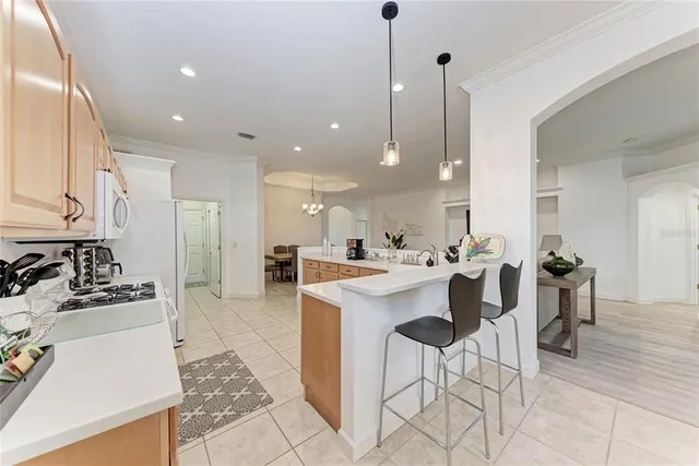 a kitchen with a dining table chairs sink and stove