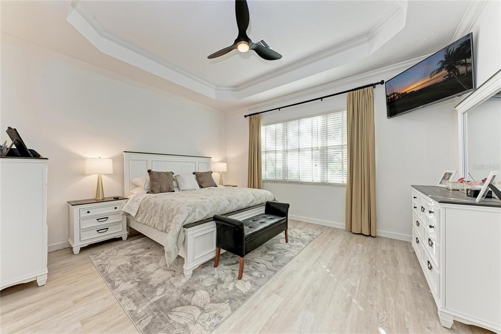 7128 Rue De Palisades, Unit 22 Sarasota, FL 34238 - Photo 19 of 41 a bedroom with a bed and a chandelier