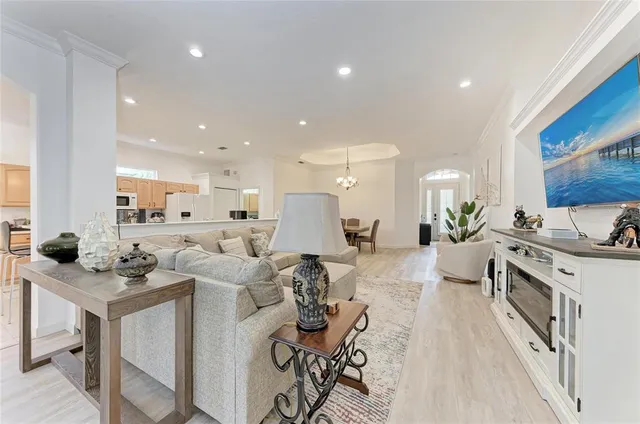 a view of a kitchen with kitchen island stainless steel appliances a stove a sink a center island and furniture