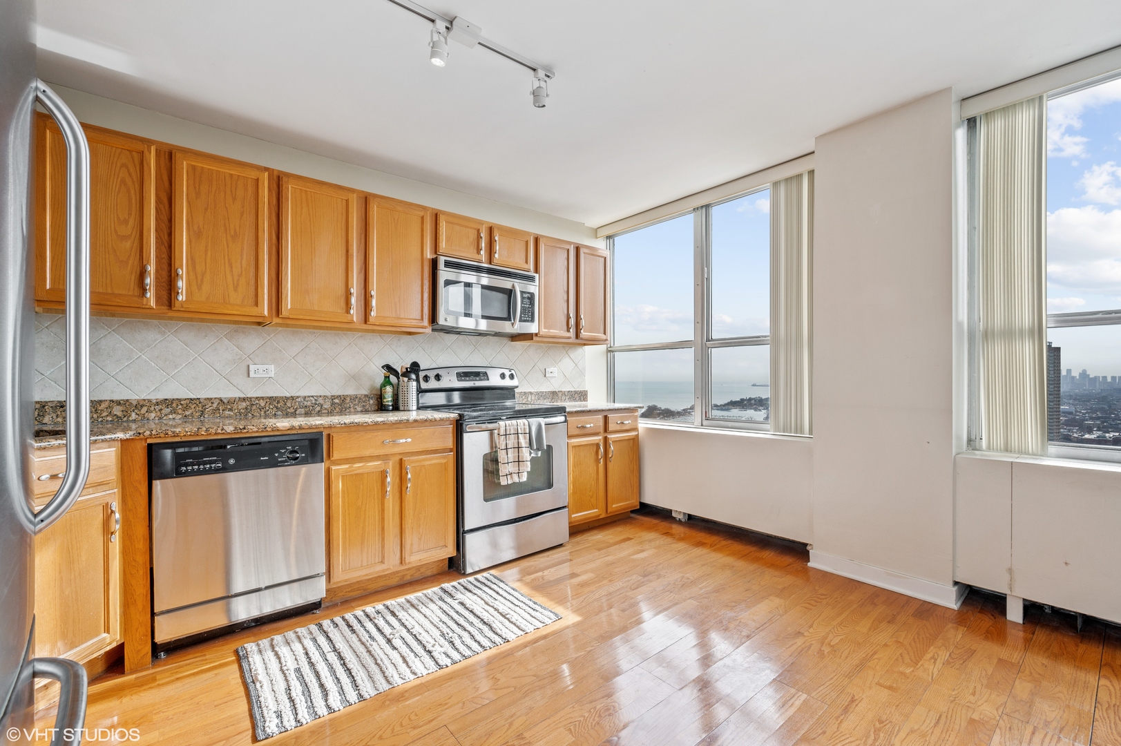 655 West Irving Park Road, Unit 4005 Chicago, IL 60613 - Photo 4 of 12 a kitchen with stainless steel appliances granite countertop a stove a sink and a refrigerator