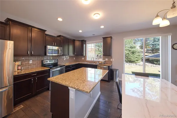 a bathroom with a granite countertop bathtub shower sink mirror and toilet