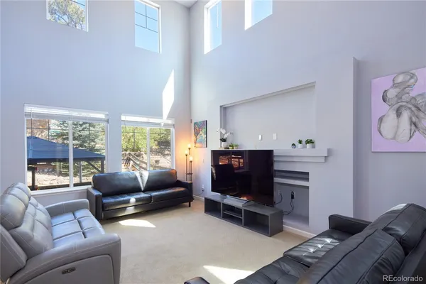 a kitchen with kitchen island granite countertop wooden cabinets a stove a sink and a large window