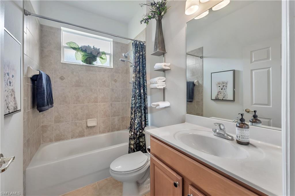 14095 Mirror Court Naples, FL 34114 - Photo 20 of 45 Full bath featuring shower / bath combo with shower curtain, vanity, and light tile patterned floors