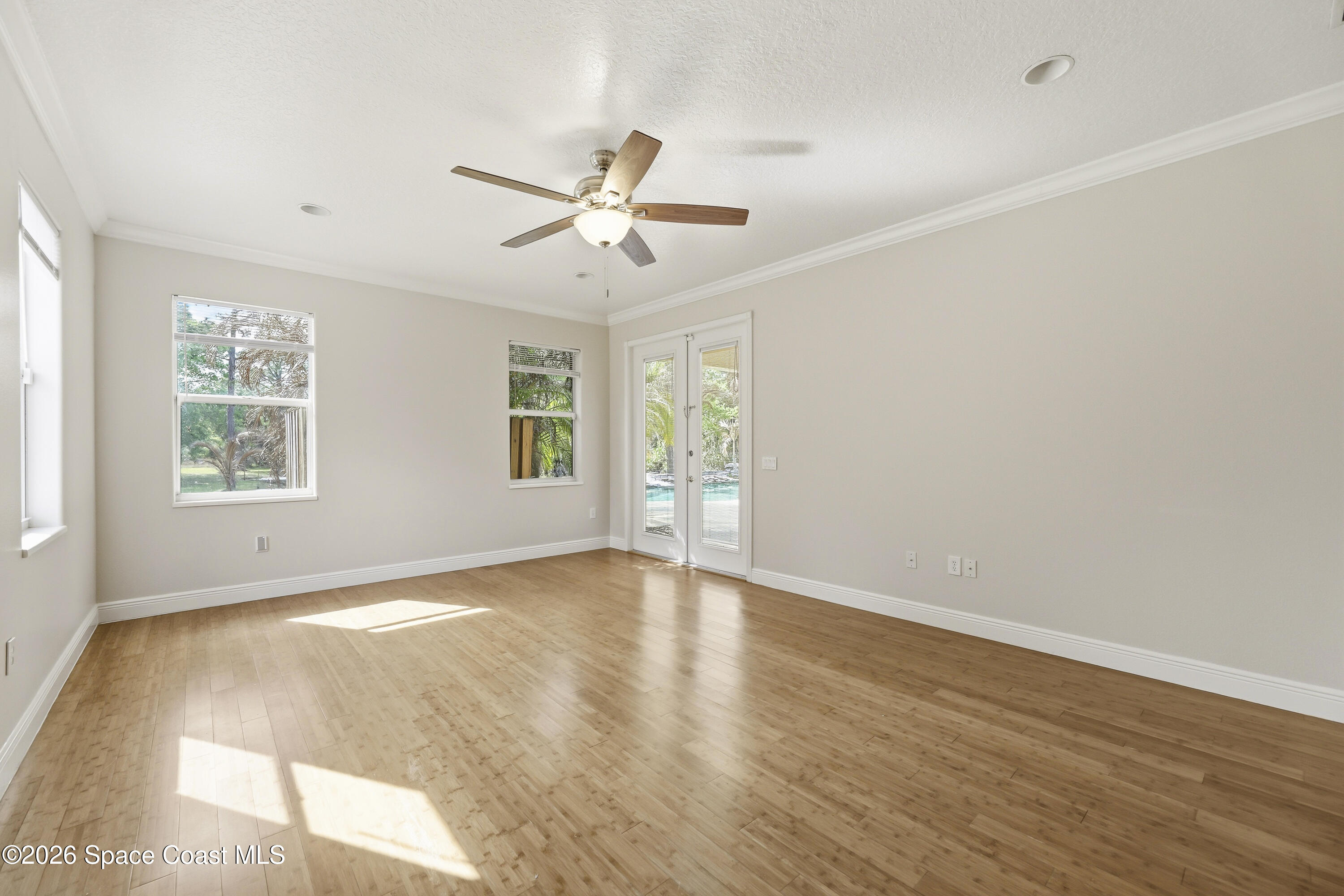 2300 Duncil Lane Malabar, FL 32950 - Photo 31 of 86 an empty room with wooden floor fan and windows