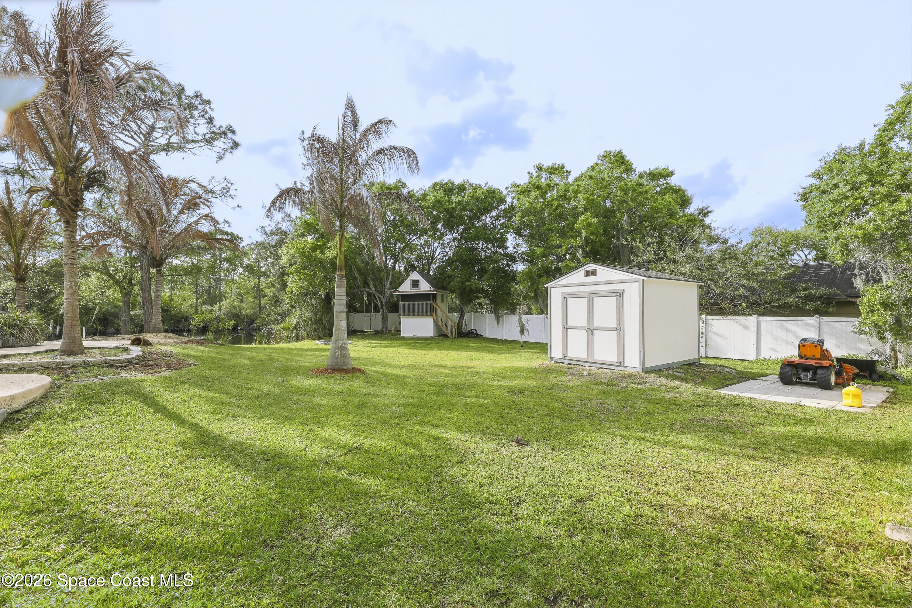 2300 Duncil Lane Malabar, FL 32950 - Photo 81 of 86 a backyard of a house with table and chairs plants and large tree