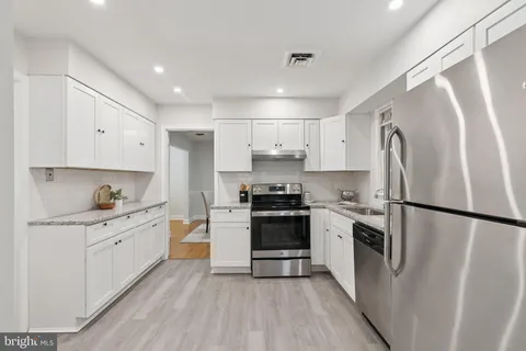 a kitchen with white cabinets and stainless steel appliances