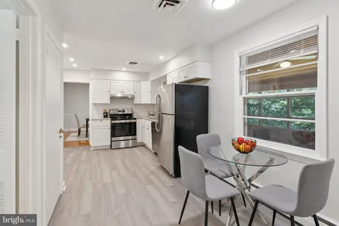 a kitchen with stainless steel appliances wooden floor and a refrigerator
