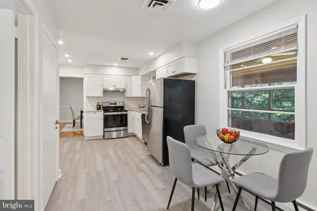 a kitchen with stainless steel appliances wooden floor and a refrigerator