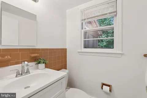 a bathroom with a sink a toilet and a mirror