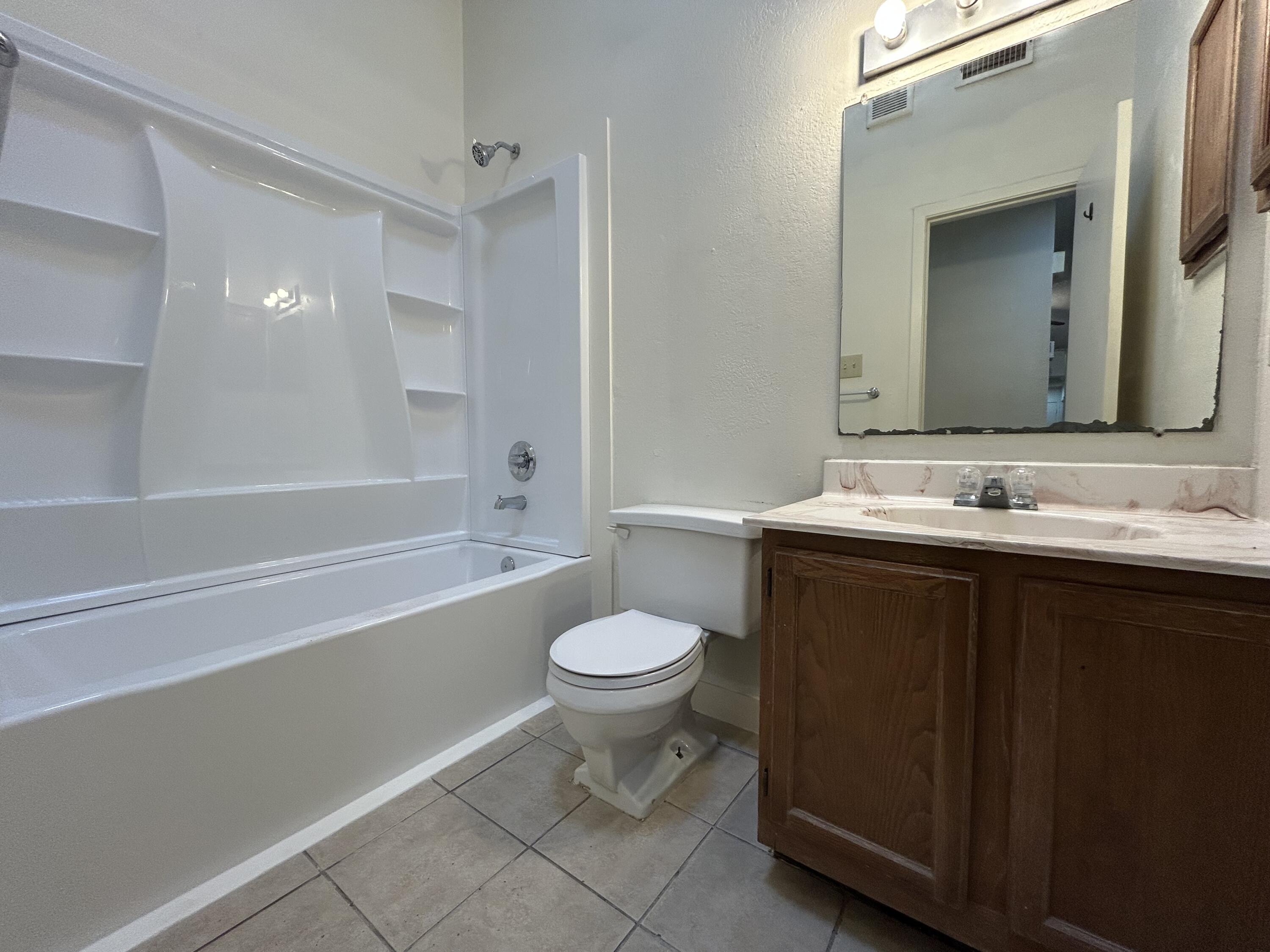 139 North Troy Avenue, Unit B Lubbock, TX 79416 - Photo 8 of 9 a bathroom with a sink a toilet and shower