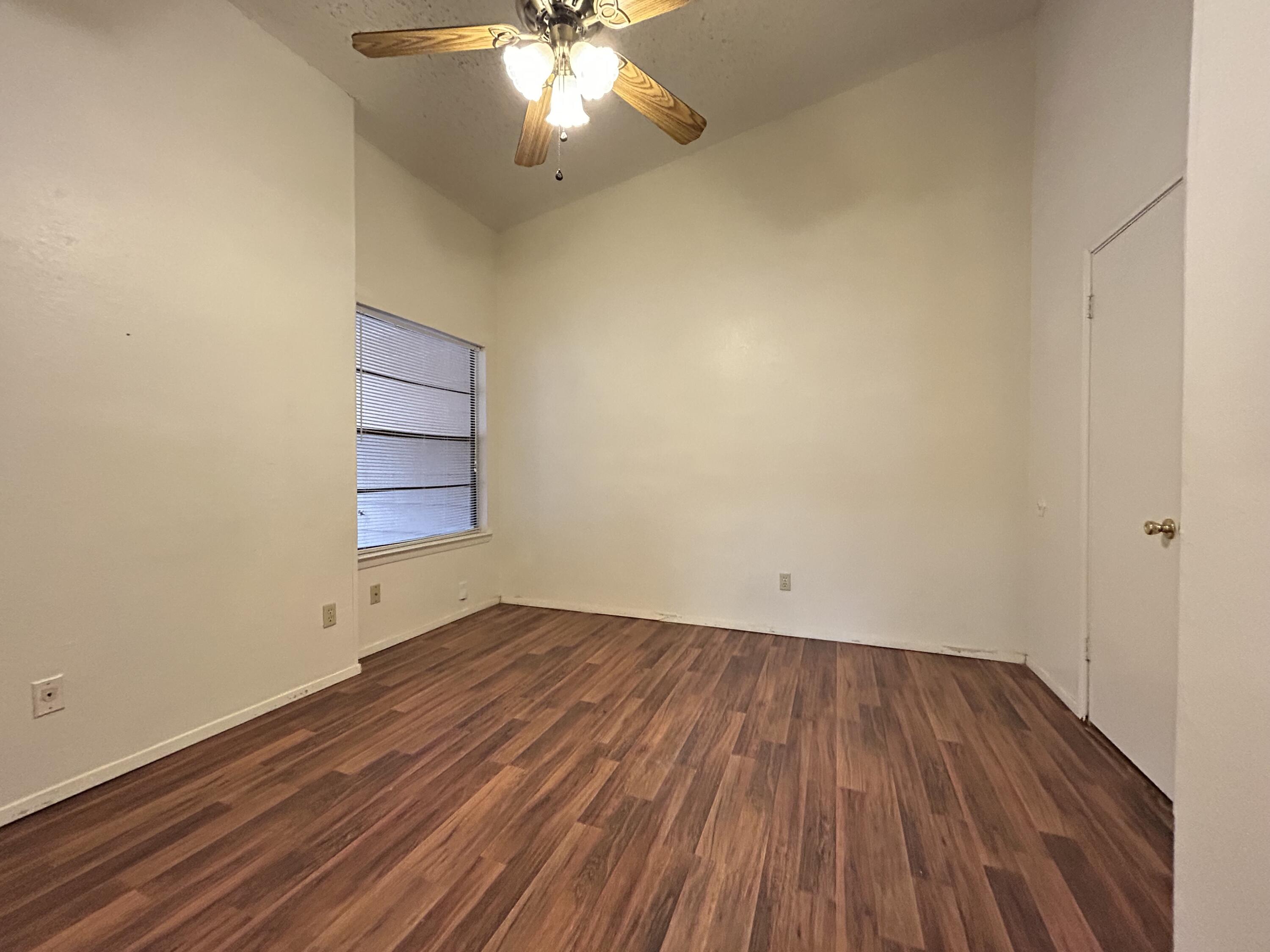 139 North Troy Avenue, Unit B Lubbock, TX 79416 - Photo 9 of 9 an empty room with wooden floor and windows