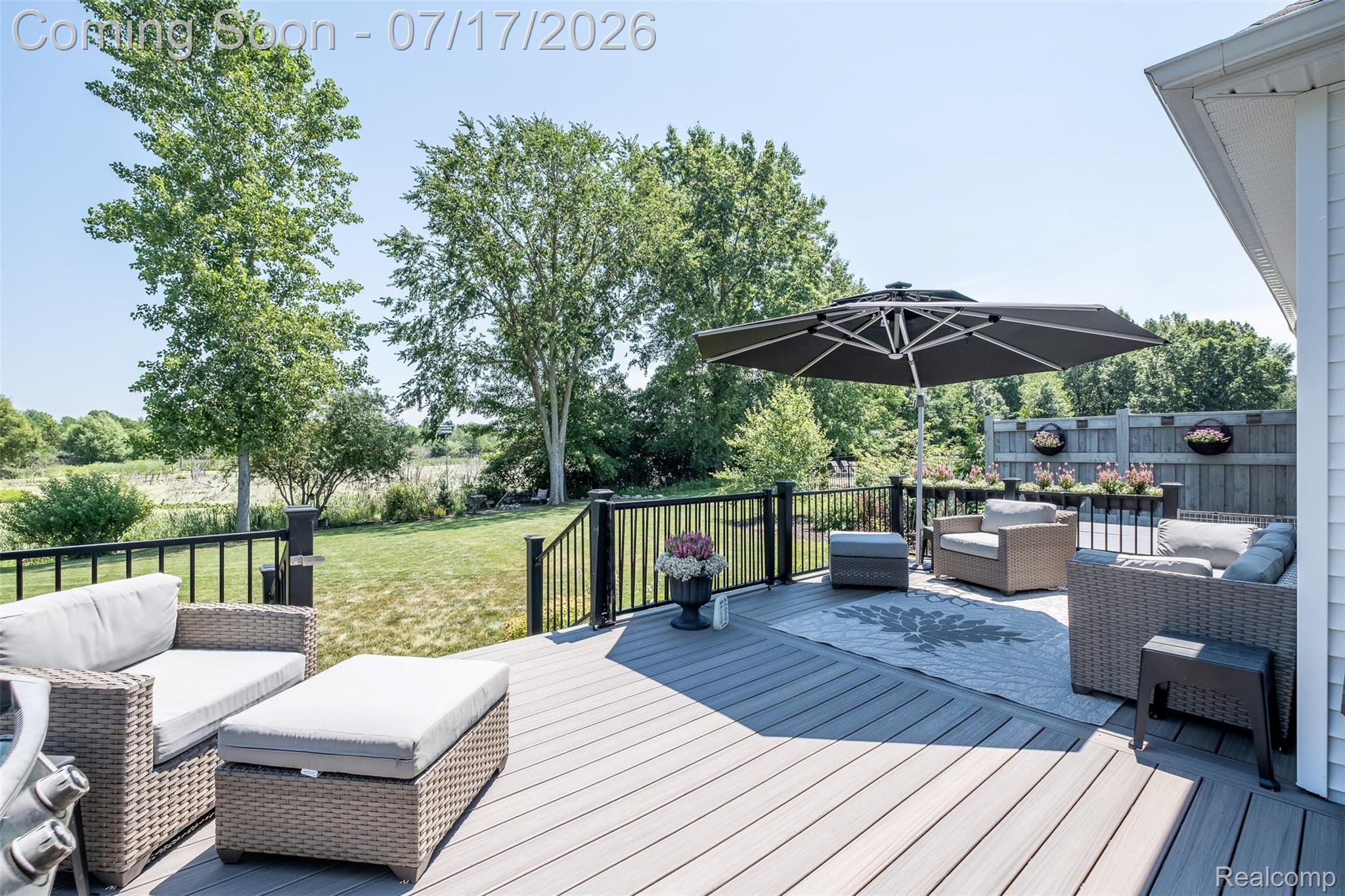12349 Sugar Maple Drive Fenton, MI 48430 - Photo 50 of 67 Expansive outdoor deck featuring composite decking, black metal railings, and a privacy fence