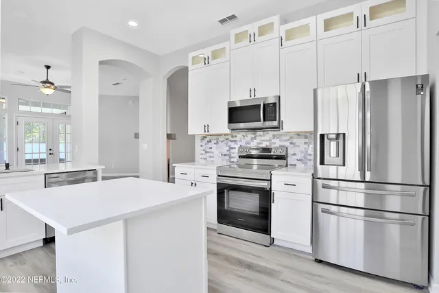 a kitchen with stainless steel appliances a refrigerator stove and microwave