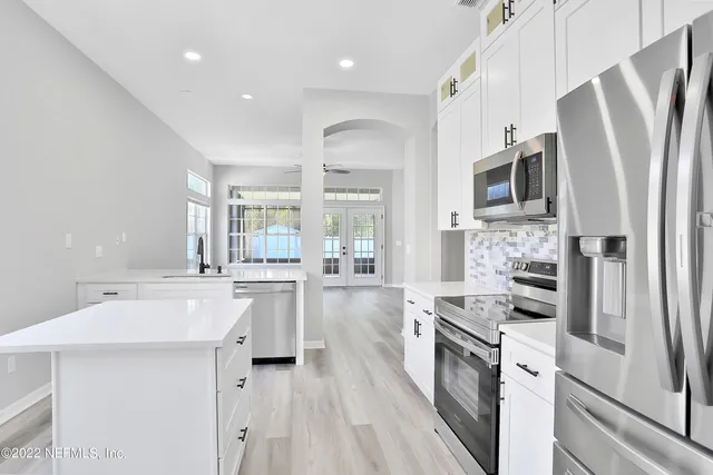a kitchen with stainless steel appliances sink stove microwave and refrigerator