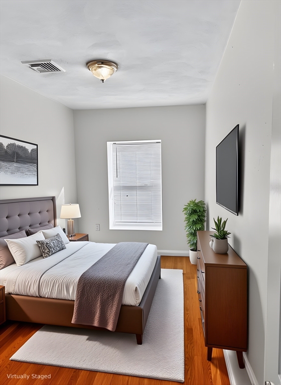 12 Paris Street, Unit 3 Boston, MA 02128 - Photo 4 of 7 a bedroom with a large bed and a flat screen tv