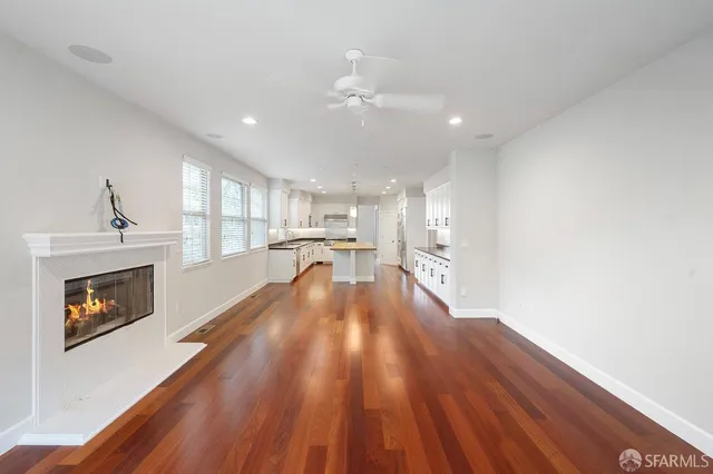 a view of a kitchen with wooden floor and a fireplace