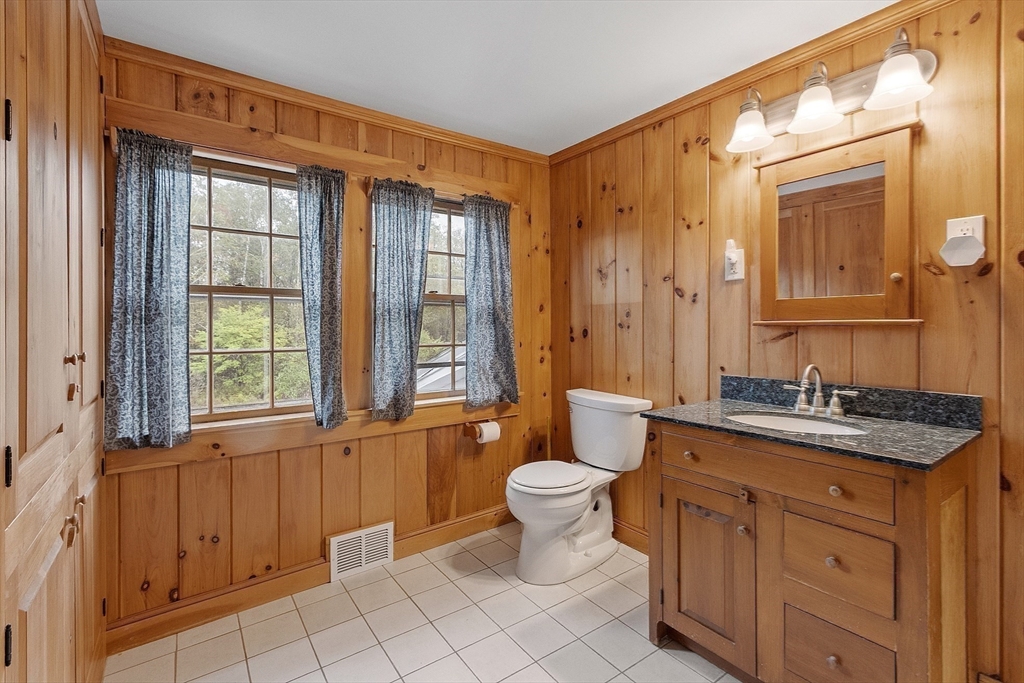 350 Athol-Richmond Road Royalston, MA 01368 - Photo 26 of 40 a bathroom with a granite countertop toilet a sink and a mirror
