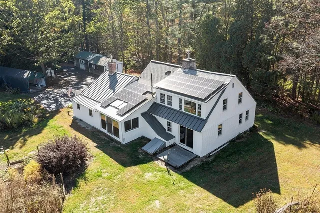 a view of a house with roof yard and sitting area