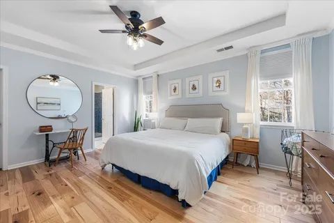 a bedroom with a bed a chandelier and a window