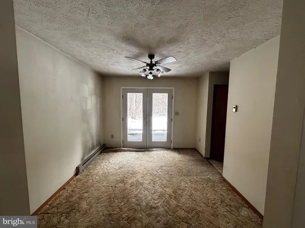 a view of a room with a ceiling fan and window