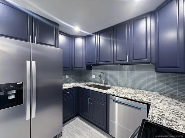 a kitchen with a sink refrigerator and cabinets