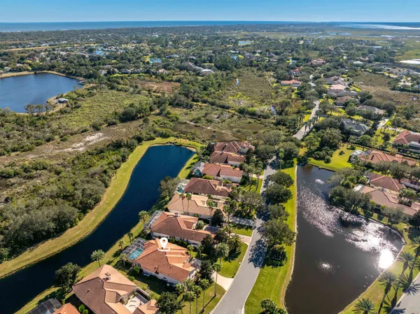 an aerial view of a city with lots of residential buildings and ocean view in back