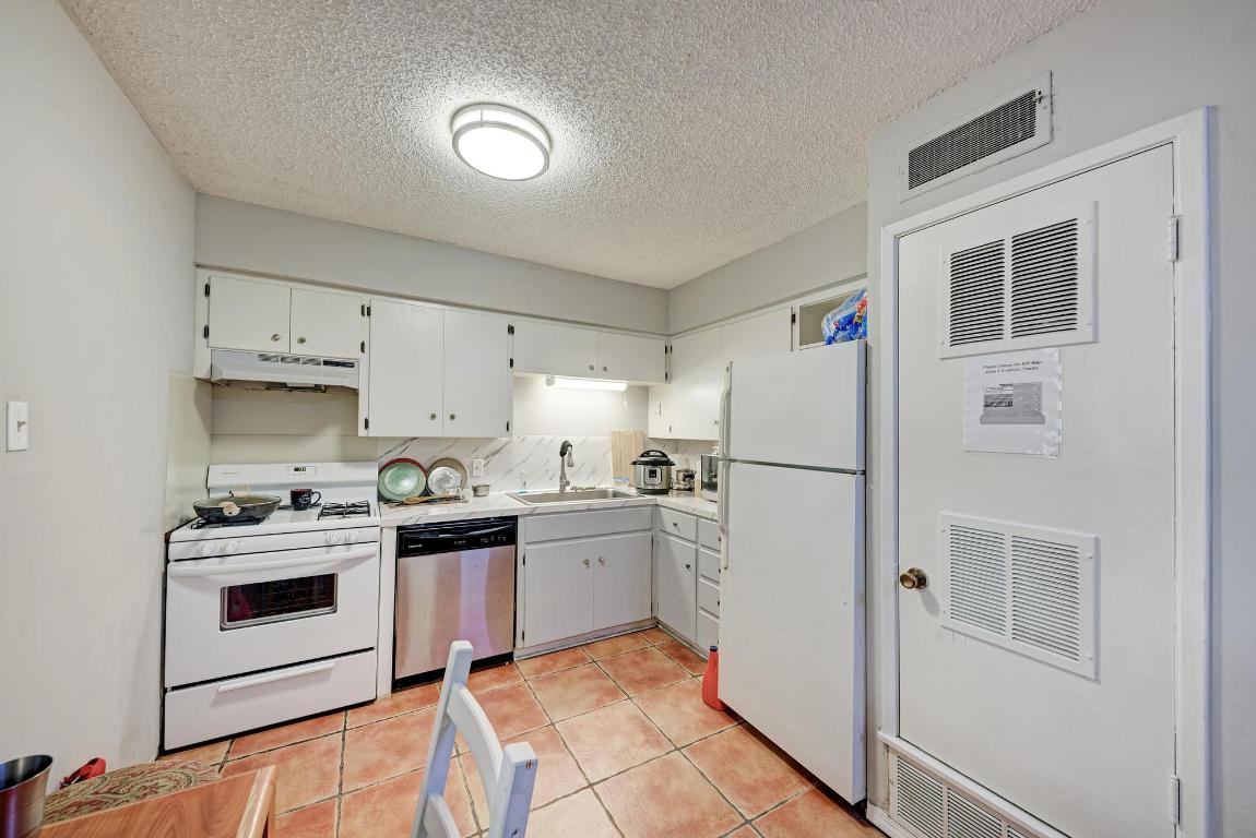 803 West 28th Street, Unit 102 Austin, TX 78705 - Photo 5 of 16 a kitchen with a stove a sink and a refrigerator