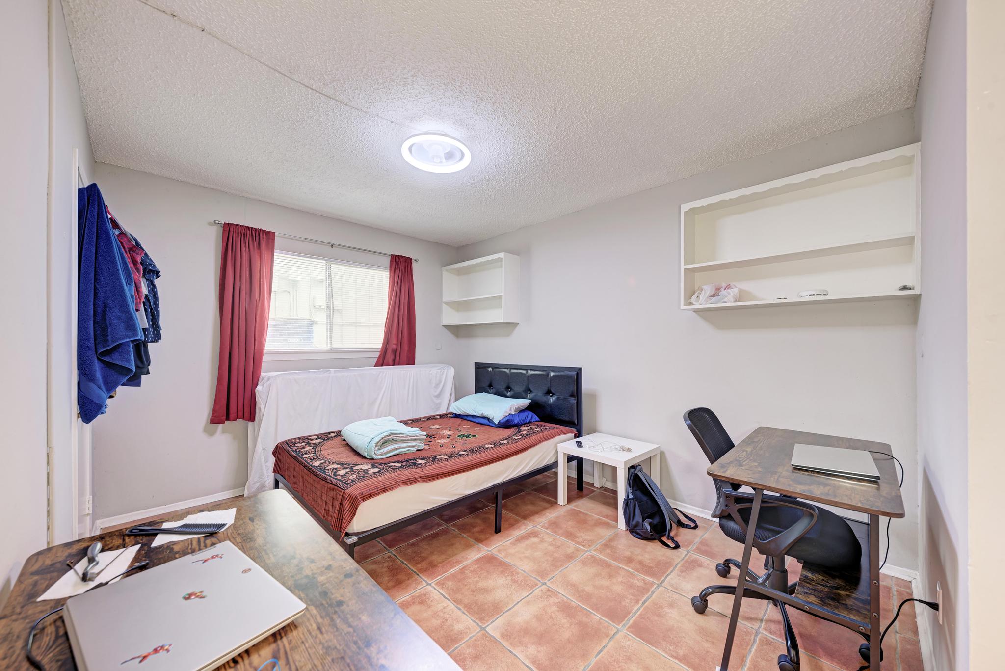 803 West 28th Street, Unit 102 Austin, TX 78705 - Photo 7 of 16 a bedroom with a bed and a desk