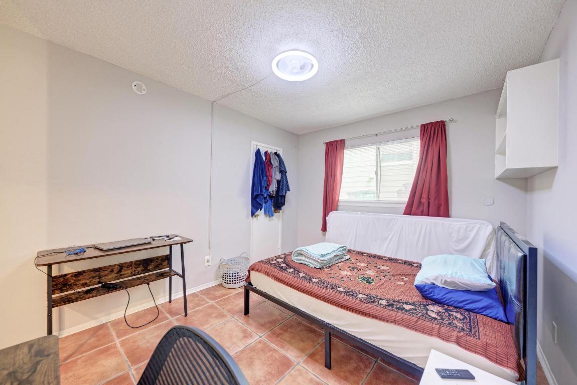 803 West 28th Street, Unit 102 Austin, TX 78705 - Photo 8 of 16 a bedroom with a bed and a dresser with rug