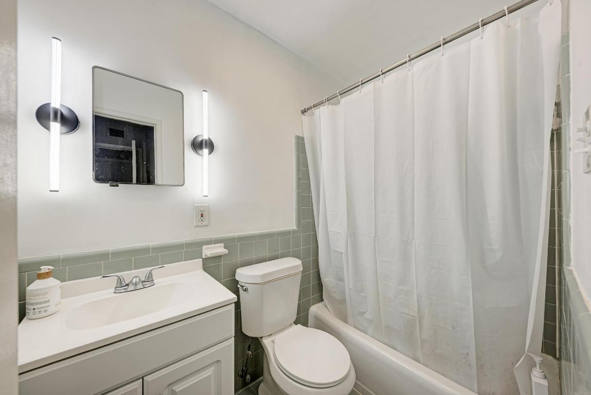 803 West 28th Street, Unit 102 Austin, TX 78705 - Photo 9 of 16 a white toilet sitting next to a bathroom sink