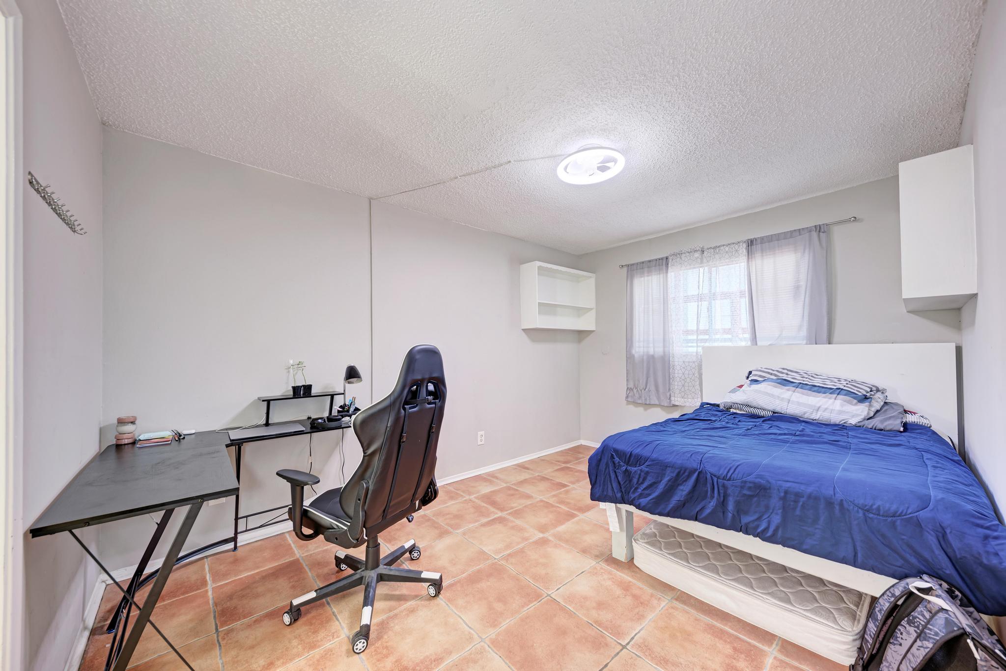 803 West 28th Street, Unit 102 Austin, TX 78705 - Photo 10 of 16 a bedroom with a bed a desk and chair